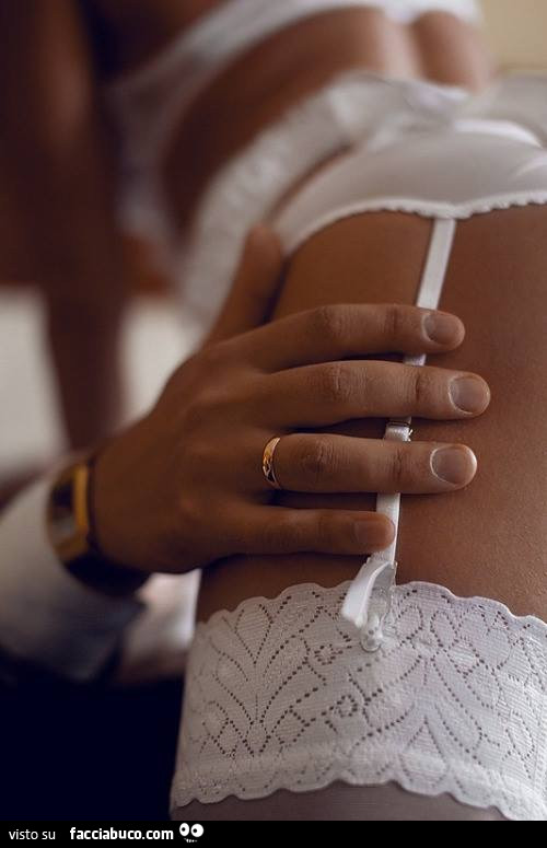 Mani sulla coscia della ragazza in lingerie bianca