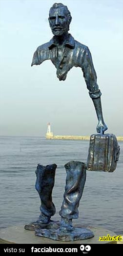 Statua di uomo con la valigia. Parte del corpo manca per lasciare intravedere il faro
