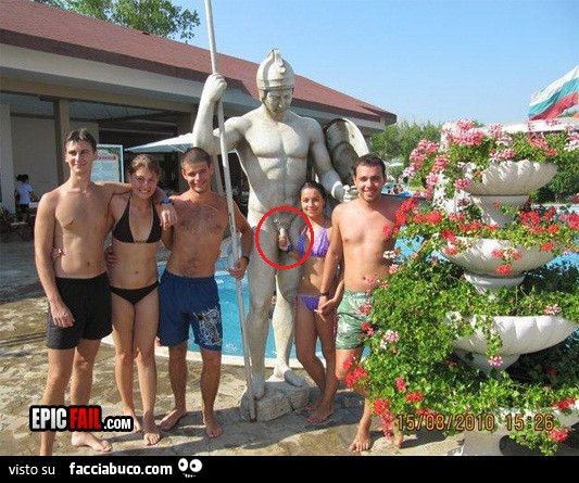 Ragazza aggrappata al pisello della statua nella foto di gruppo