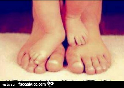 Piedi di bimbo sopra piedi della mamma